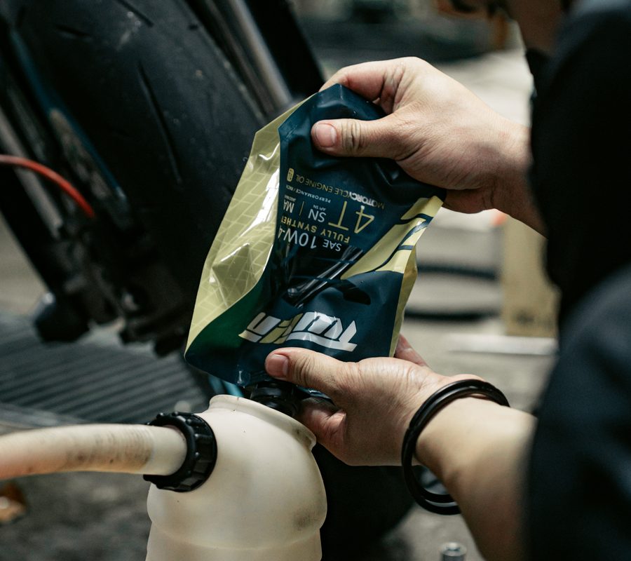 Pouring TWIIN engine oil from the flexible spout pouch